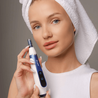 Femme avec une serviette autour des cheveux tenant un stylo Dr. Pen A11 microneedling – appareil de soin de la peau professionnel pour une peau plus lisse et plus ferme.