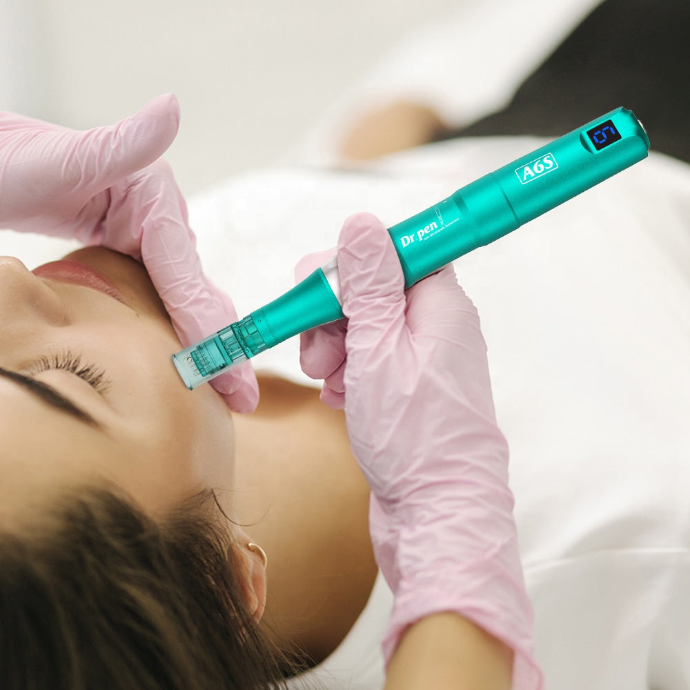 Microneedling professionnel avec Dr. Pen A6S où une personne portant des gants effectue un soin du visage sur un client allongé et détendu.