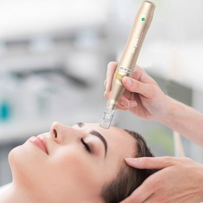 Une personne est allongée détendue pendant qu'un praticien effectue microneedling sur le front avec un Dr. Pen M5 doré. Le praticien tient le stylo avec les deux mains pour plus de précision.