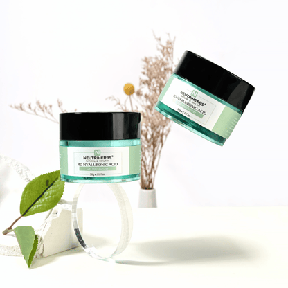 Image lifestyle de Neutriherbs 4D Hyaluronic Acid Gel Moisturizer 50 g. Deux pots de cette crème-gel hydratante sont présentés dans un environnement lumineux et épuré avec des détails naturels qui évoquent une routine de soin fraîche et une hydratation intense.